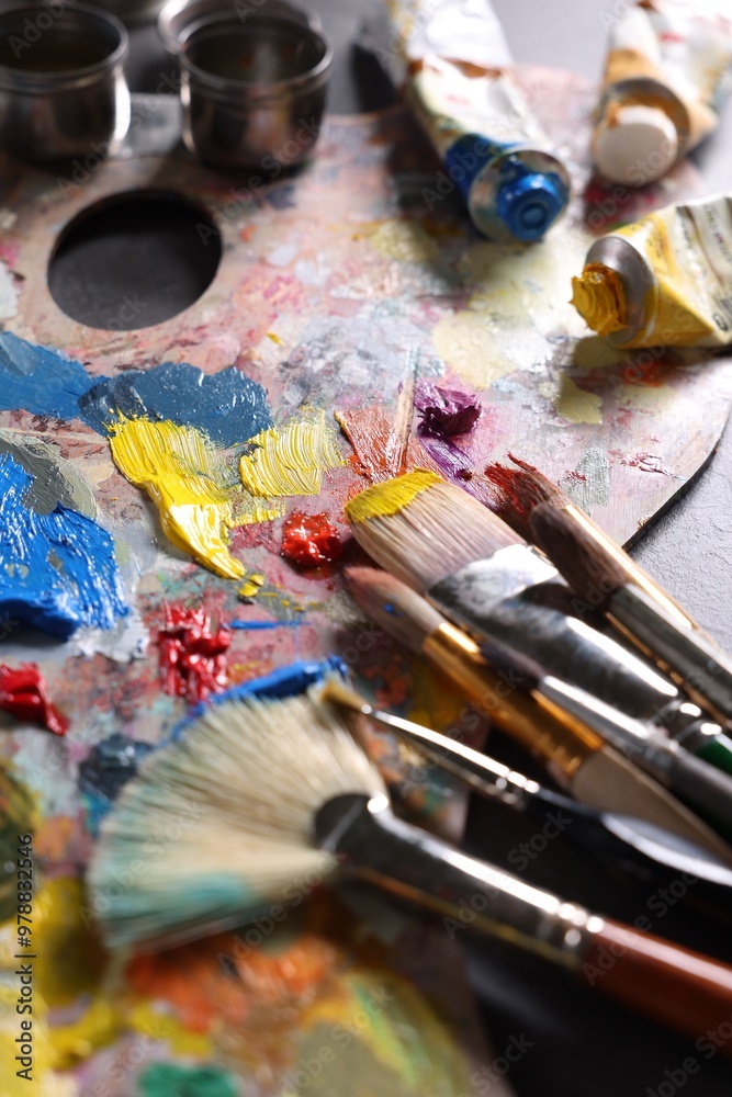 Artist's palette, brushes and paints on grey table, closeup Artist's palette, brushes and paints on grey table, closeup