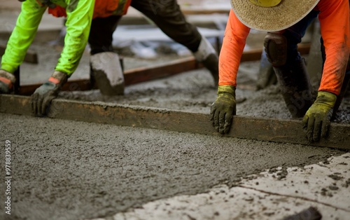 road crew spreading the wet concrete across the road