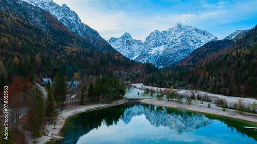 The Jasna lake with beautiful reflections of the mountains. Triglav National Park, Slovenia mountain village environs, grassy hills. Picturesque traveling