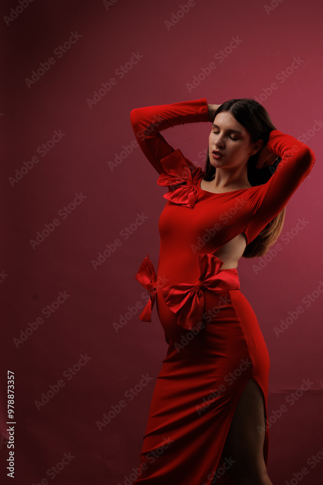 Beautiful young pregnant brunette girl. A woman waiting for a baby in a red dress with bows, on red background, in the studio. Beautiful young pregnant brunette girl. A woman waiting for a baby in a red dress with bows, on red background, in the studio.