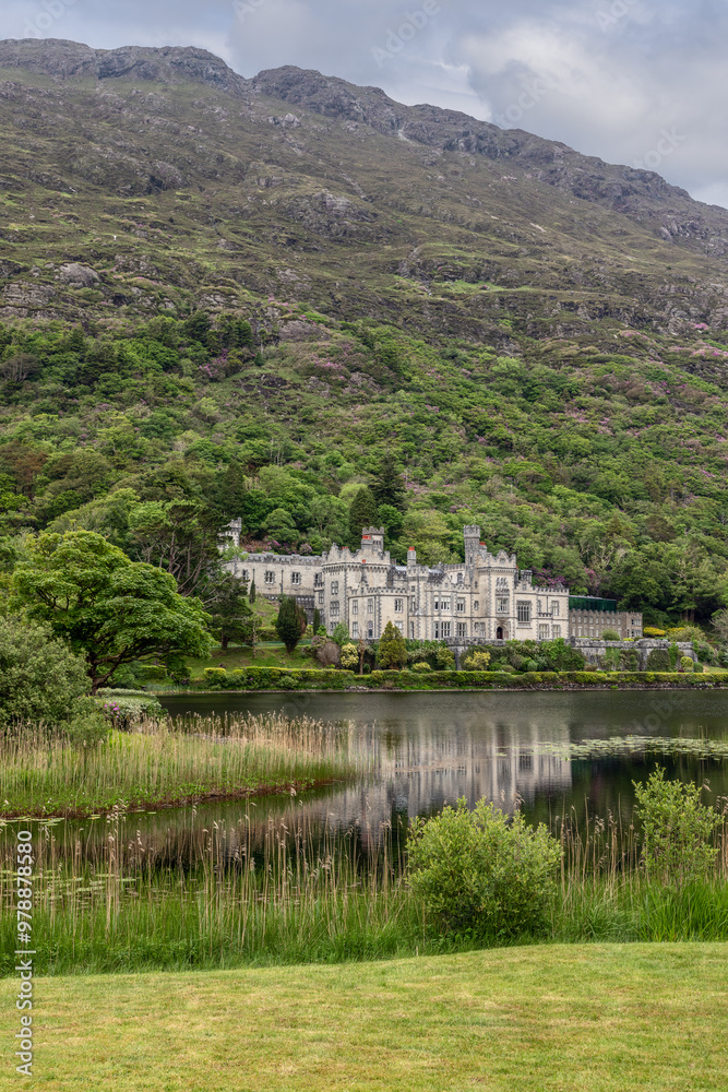 Vertical photo of Kylemore Abbey by Pollacapall Lough in Connemara, Ireland. The historic abbey reflects in the tranquil lake Vertical photo of Kylemore Abbey by Pollacapall Lough in Connemara, Ireland. The historic abbey reflects in the tranquil lake