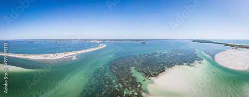 Aerial view of colorful boats navigating through Hurricane Pass and coral reef with sandy sandbanks, Dunedin, Florida, United States.