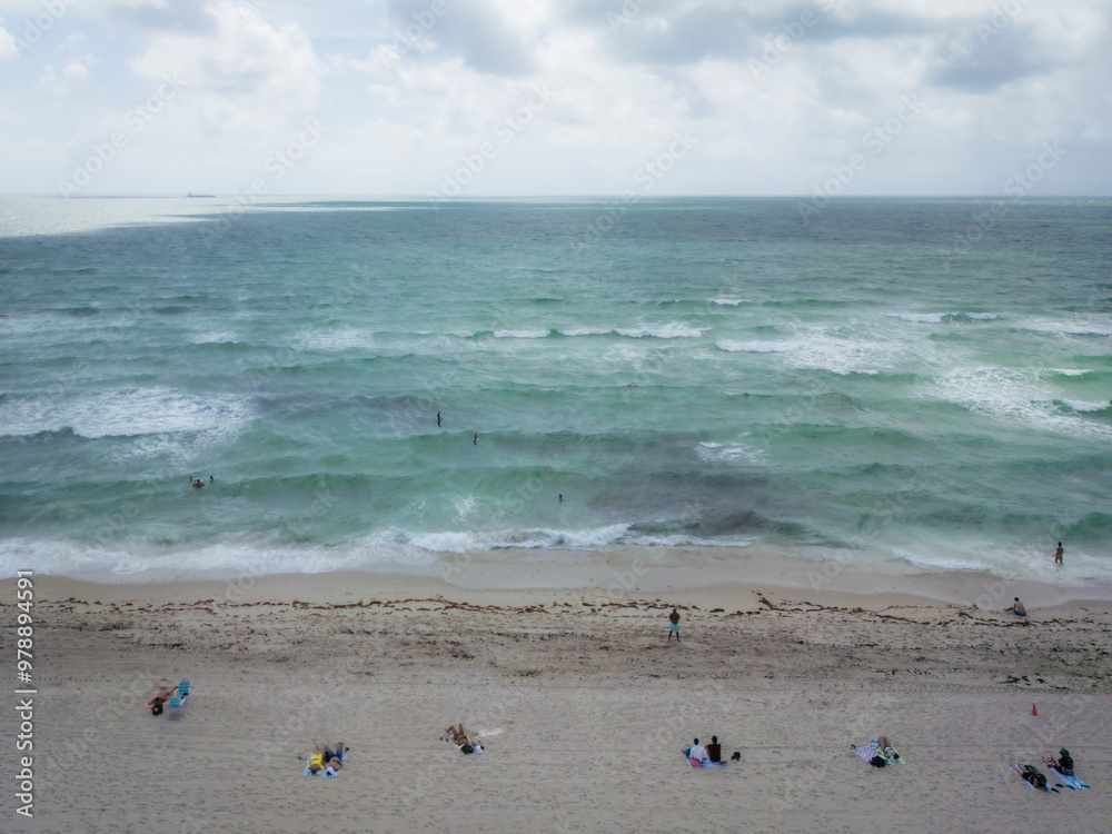 Aerial view of people enjoying a beautiful beach with lifeguard house and tranquil ocean, Miami Beach, United States. Aerial view of people enjoying a beautiful beach with lifeguard house and tranquil ocean, Miami Beach, United States.