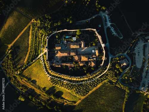 Aerial view of picturesque medieval fortress village surrounded by green vineyards and stone walls, Monteriggioni, Italy. photo