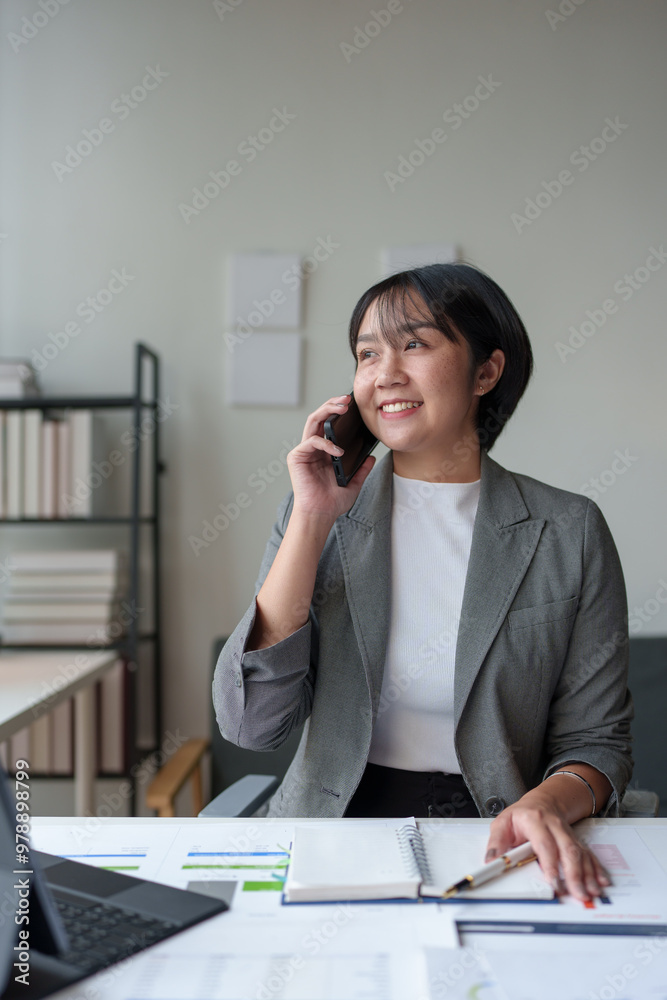 Confident Asian businesswoman happy while using smartphone for business work in finance, online marketing, communication business concept, work contact. Confident Asian businesswoman happy while using smartphone for business work in finance, online marketing, communication business concept, work contact.