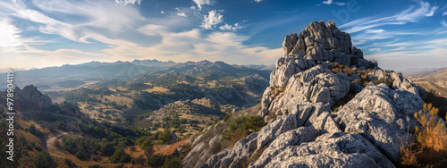 A rugged granite peak, rising majestically above the surrounding landscape, with panoramic views of the rugged terrain below photo
