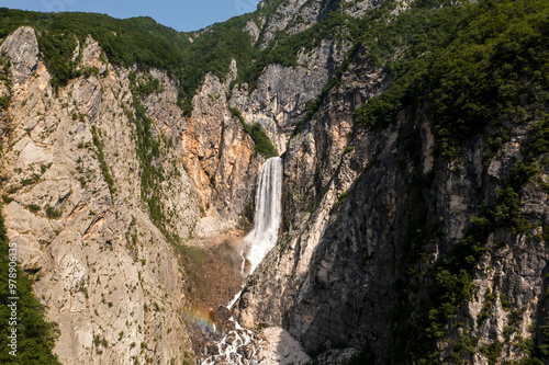 Aerial view of a majestic waterfall cascading down a rugged cliff surrounded by lush forest and pristine nature, Pluzna, Slovenia. photo