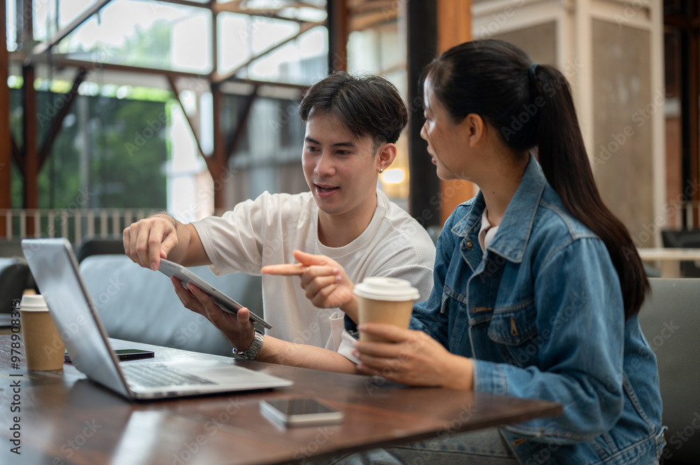 Two Asian college friends or colleagues are discussing work at a coffee shop, sharing their ideas. Two Asian college friends or colleagues are discussing work at a coffee shop, sharing their ideas.