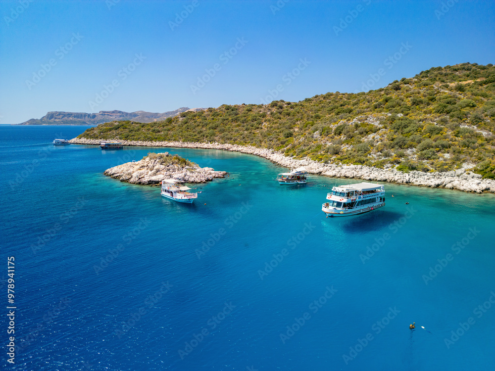 Aerial view of a beautiful dive boat near a turquoise island in the Mediterranean Sea, Kas, Turkey. Aerial view of a beautiful dive boat near a turquoise island in the Mediterranean Sea, Kas, Turkey.
