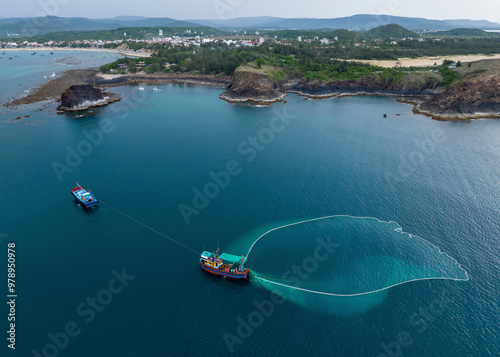 Aerial view of big net fishing in the tranquil ocean with fishing boats and scenic shoreline, Tuy An, Phu Yen, Vietnam. photo