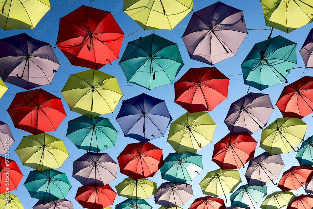 Colorful array of suspended umbrellas against a blue sky Colorful array of suspended umbrellas against a blue sky