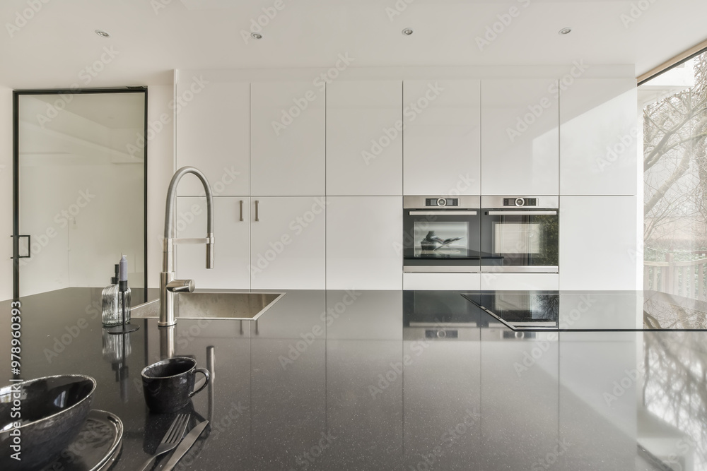Modern kitchen with sleek white cabinets and black countertop Modern kitchen with sleek white cabinets and black countertop