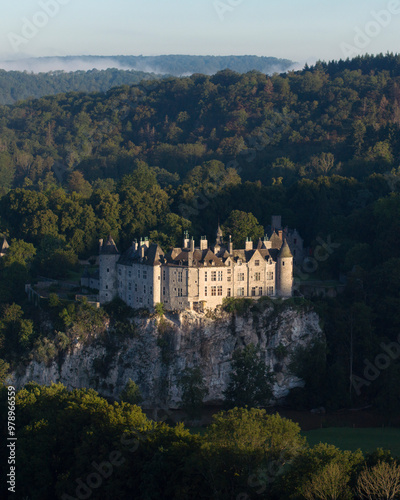 Aerial view of the medieval Walzin castle surrounded by tranquil forest and a river at sunrise, Dinant, Belgium. photo