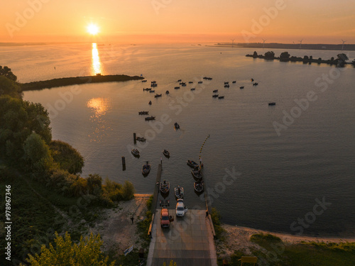 Aerial view of fishing boats at a ramp during sunrise over the serene Haringvliet waterway, Ooltgensplaat, Netherlands. photo