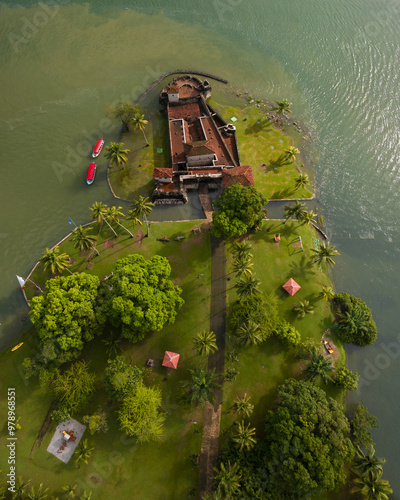 Aerial view of the medieval castillo de san felipe fortress by the lake surrounded by lush greenery and palm trees, Rio Dulce, Guatemala. photo