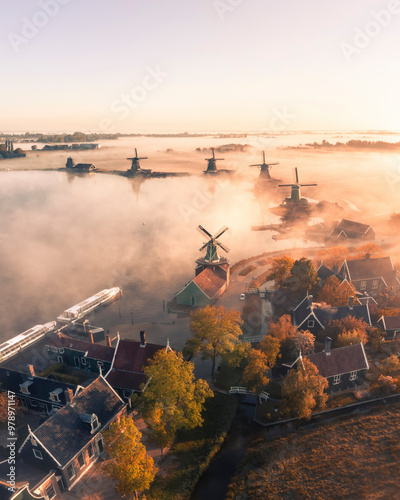 Aerial view of traditional windmills in fog at sunrise, Zaanse Schans, Netherlands. photo