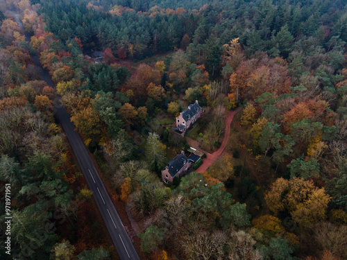 Aerial view of a beautiful sunset over a forest with a house and winding road, Appelscha, Netherlands. photo