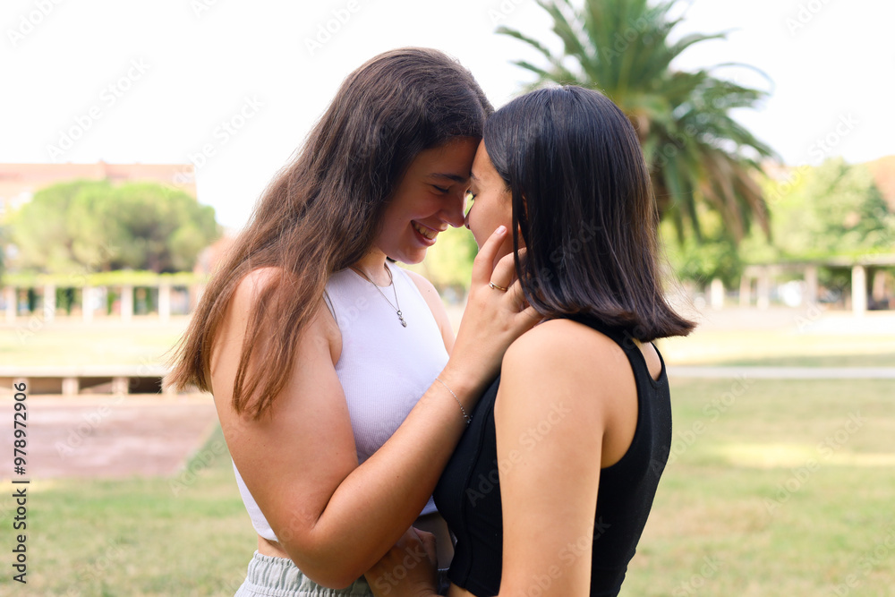 Tender moment between lesbian couple at park Tender moment between lesbian couple at park