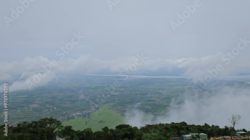 Fog and sky clouds at Tay Ninh province, Vietnam, capturing from Ba Den mountain. Beautiful landscape with rice fields, river and residential areas.  photo