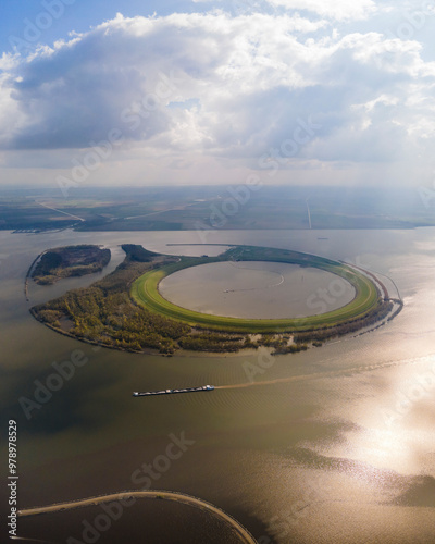 Aerial view of tranquil Ketelmeer lake with a serene vessel and circular island, Flevoland, Netherlands. photo