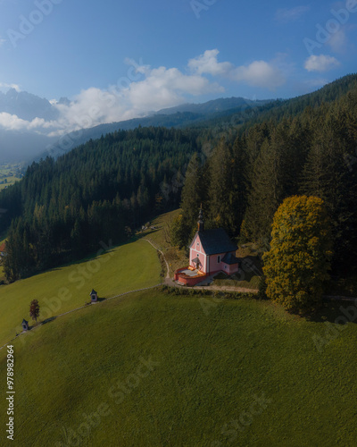 Aerial view of a picturesque church and chapel in a lush valley surrounded by serene mountains and forests, Gosau, Austria. photo