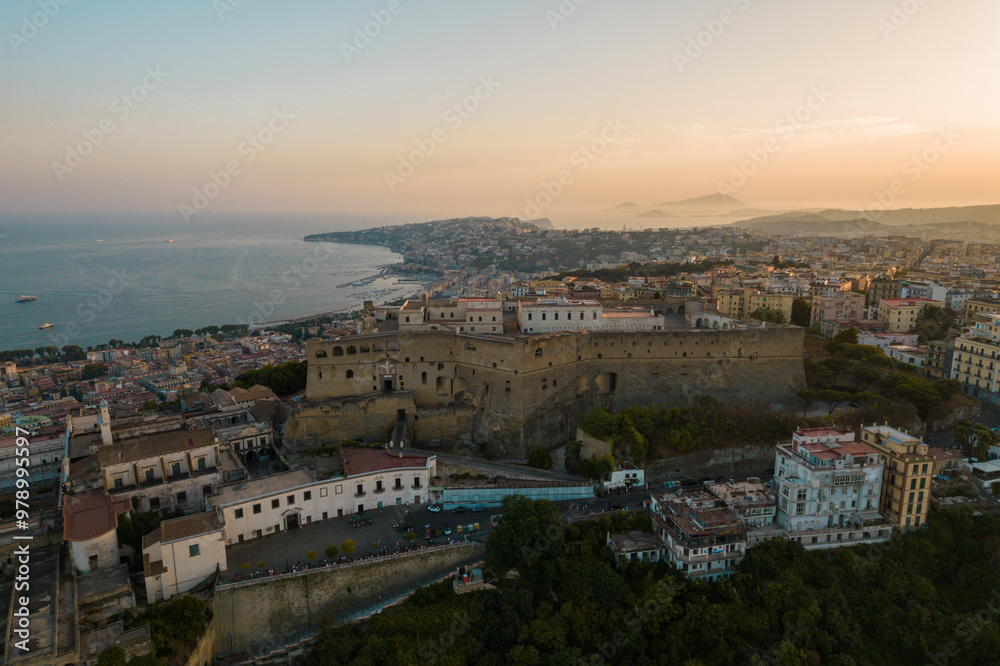 Aerial view of beautiful sunset over the cityscape of Naples with historic castle and picturesque coastline, Vomero Hill, Italy. Aerial view of beautiful sunset over the cityscape of Naples with historic castle and picturesque coastline, Vomero Hill, Italy.