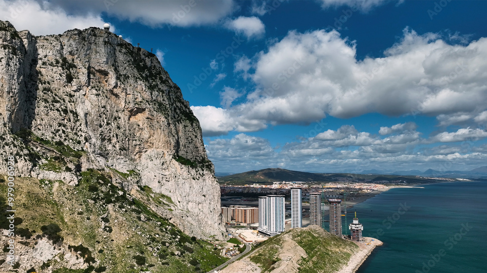 Aerial view of the majestic rock of Gibraltar overlooking the tranquil ocean and picturesque village, Gibraltar. Aerial view of the majestic rock of Gibraltar overlooking the tranquil ocean and picturesque village, Gibraltar.