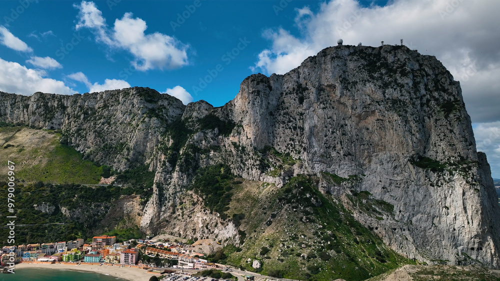 Aerial view of the majestic Rock of Gibraltar overlooking the ocean and a picturesque village, Gibraltar. Aerial view of the majestic Rock of Gibraltar overlooking the ocean and a picturesque village, Gibraltar.