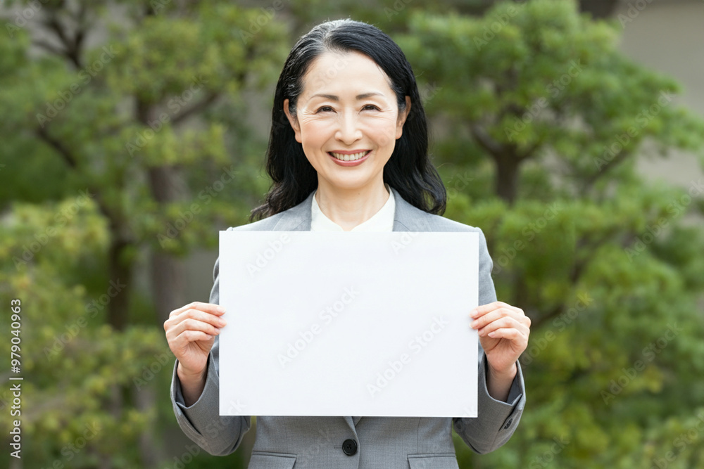 白紙の紙を正面に持つ女性 白紙の紙を正面に持つ女性