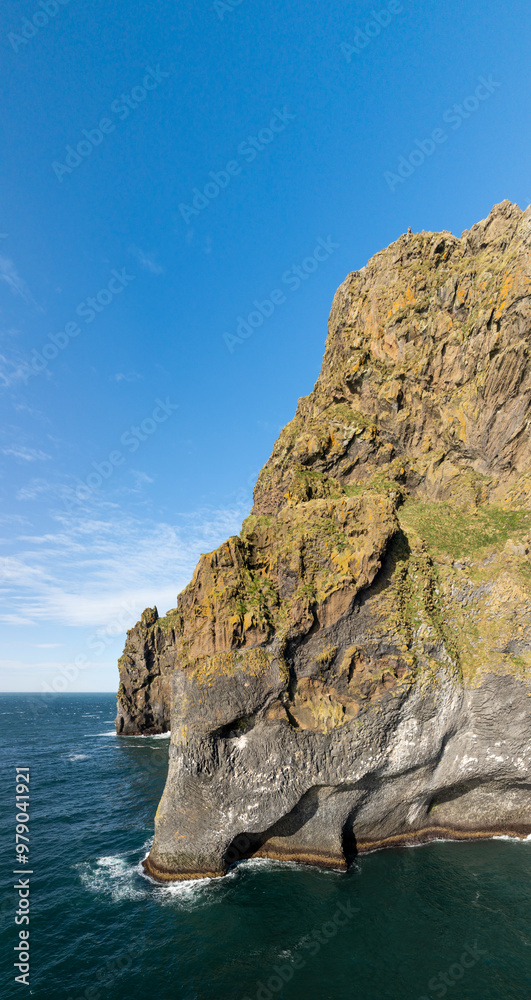 Aerial view of majestic elephant rock and rugged cliffs by the serene ocean, Vestmannaeyjar, Iceland. Aerial view of majestic elephant rock and rugged cliffs by the serene ocean, Vestmannaeyjar, Iceland.