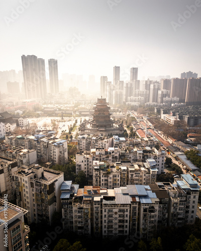 Aerial view of gui yuan temple surrounded by skyscrapers and a bustling urban landscape at sunset, wuhan, china.