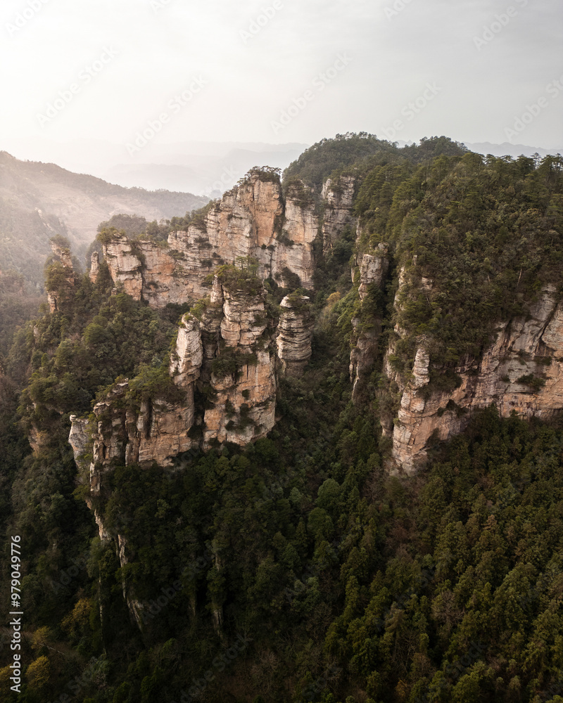 Aerial view of majestic mountains and lush forest with dramatic cliffs in a scenic valley, Zhangjiajie, Hunan, China. Aerial view of majestic mountains and lush forest with dramatic cliffs in a scenic valley, Zhangjiajie, Hunan, China.