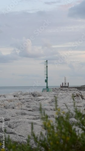 The seamark on the shore lights up. Cloudy sky with the light of seamark. Sea coast navigation.