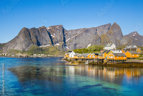 Aerial view of the picturesque fishing village with colorful wooden houses and serene water reflections, Lofoten, Norway.