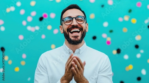 Enthusiastically Clapping Hands After Receiving an Unexpected Reward   A jubilant man expressing joy and over a triumph or achievement in a vibrant out of focus outdoor setting photo