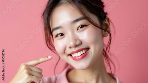 Beautiful young Asian woman pointing finger to her teeth on isolated pink background. Facial and skin care concept for commercial advertising : Generative AI