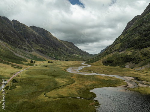 Aerial view of loch achtriochtan surrounded by majestic mountains and a tranquil valley under a cloudy sky, ballachulish, united kingdom. photo