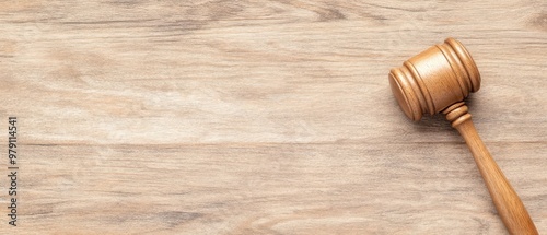 A wooden gavel rests on a smooth wooden surface, symbolizing justice and law, suitable for legal themes and courtroom imagery.