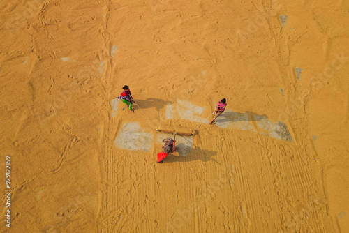 Aerial view of sun dried paddy fields and rice mill with workers, Brahmanbaria, Bangladesh. photo