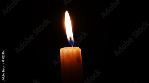 Close-up single candle burning on dark black background, candle fire flame light.