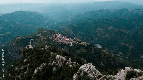 Aerial view of a picturesque mountain village nestled in a lush green valley with rugged terrain, Spileo, Greece. photo