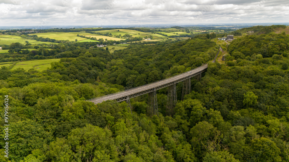 Aerial view of lush Meldon viaduct spanning a tranquil valley surrounded by serene woodland, Okehampton, United Kingdom. Aerial view of lush Meldon viaduct spanning a tranquil valley surrounded by serene woodland, Okehampton, United Kingdom.