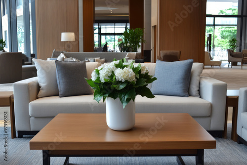 Hotel lobby featuring a cozy sofa and a vase with fresh flowers