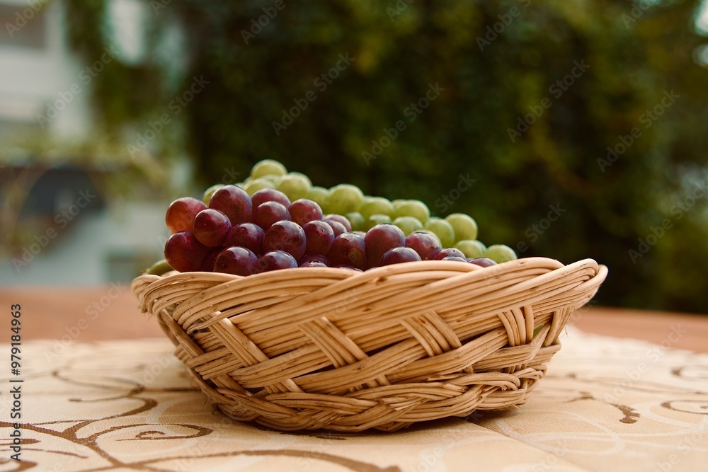 Korb für das Erntedankfest gefüllt mit frischem Obst, Weintrauben in rot und grün nach der Lese auf einem Restauranttisch Korb für das Erntedankfest gefüllt mit frischem Obst, Weintrauben in rot und grün nach der Lese auf einem Restauranttisch