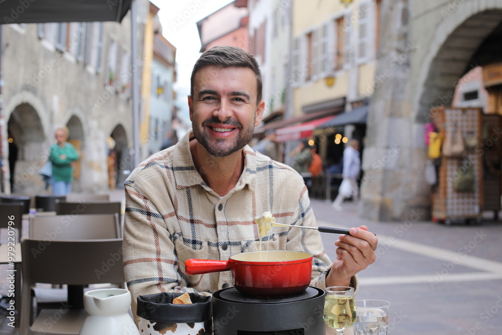 Handsome man enjoying a fondue in Europe 