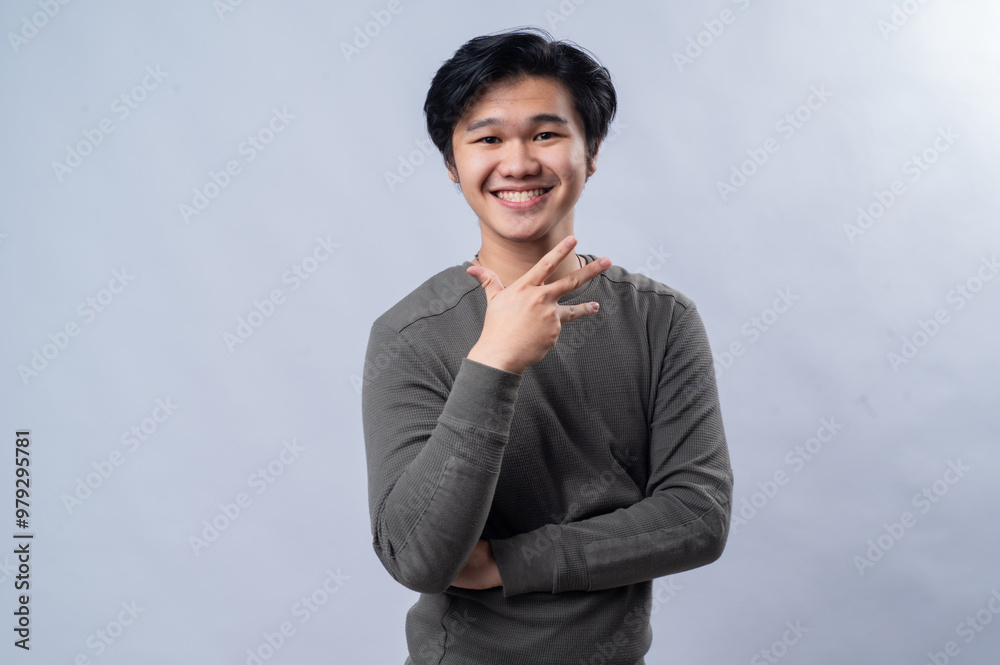 Portrait of an Asian person wearing a long-sleeved gray shirt, showing a specific number with their fingers, isolated against a white background. Portrait of an Asian person wearing a long-sleeved gray shirt, showing a specific number with their fingers, isolated against a white background.
