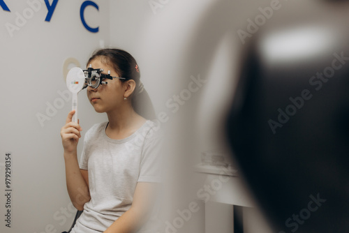 Optometrist examines the sight of young girl photo