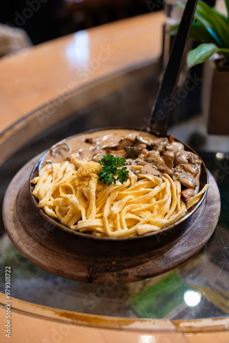 Swabian or German Bavarian specialty cuisine: Mushroom sauce with meat and Spaetzle served in a cast iron pan photo