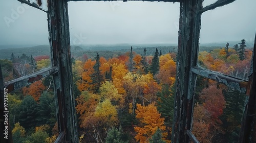 Stunning panoramic view of vibrant autumn foliage in a lush mountainous forest framed by a rustic wooden window  The scene is a captivating display of nature s vibrant colors and serene beauty photo