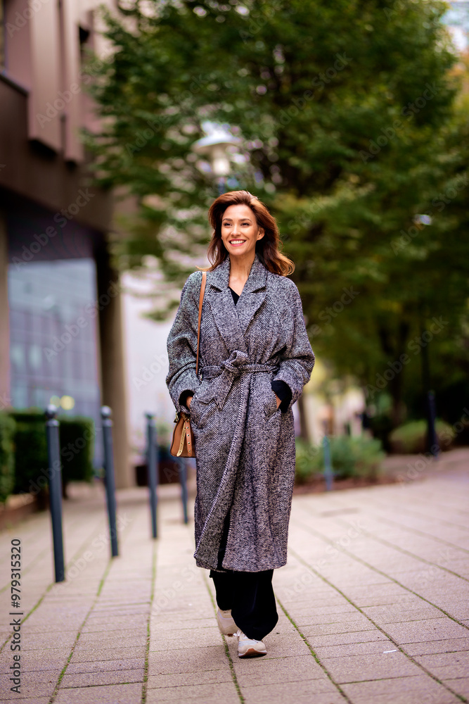 Attractive mid aged woman walking outdoors in city street on autumn day Attractive mid aged woman walking outdoors in city street on autumn day